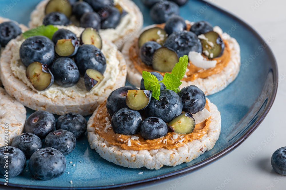 Open sandwich with blueberries. Made from rice crispbreads and peanut butter, healthy nutritious snack option, vegan food
