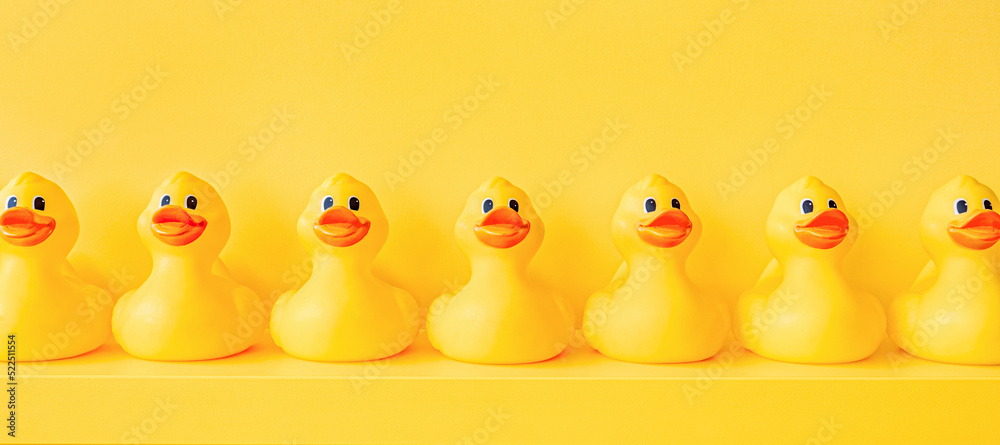 Banner yellow rubber ducks in a line toy design shelf decor. Rubber duck  background. Rubber ducky bath toy background yellow ducks in a row.  Meeting. Community. Association. Organize. Yellow concept Stock Photo