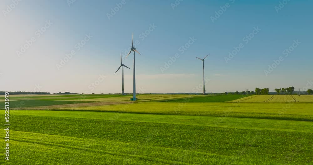 Aerial drone view of wind power turbines, part of a wind farm. Wind turbines on green field in countryside. Wind power plant. Aerial drone view of wind power turbines, part of a wind farm. Wind turbines on green field in countryside. Wind power plant.