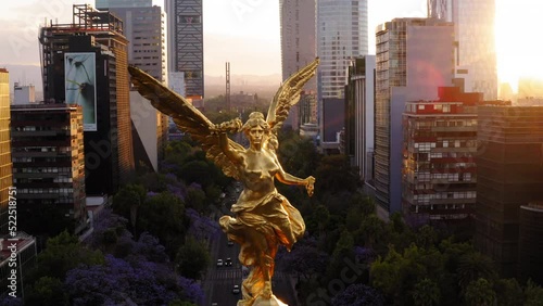 Aerial Shot Of The Angel Of Independence On Road In City, Drone Flying Backwards During Sunset - Mexico City, Mexico photo
