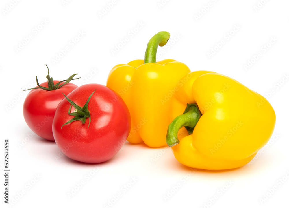 Fresh vegetables, whole red tomato and yellow bell pepper (paprika) isolated on white background