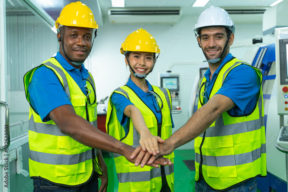 Group of young multiethnic confident male and female Engineers and Worker in safety uniform and helmet join hand together in factory. Successful business and teamwork Group of young multiethnic confident male and female Engineers and Worker in safety uniform and helmet join hand together in factory. Successful business and teamwork