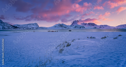 Stunning Winter scenery of Norway. Boosen fjord on Lofotens islands during sunrise. Picturesque nature scene with colorful sky, mountains and photographers on the fjord coast Norway, Europe