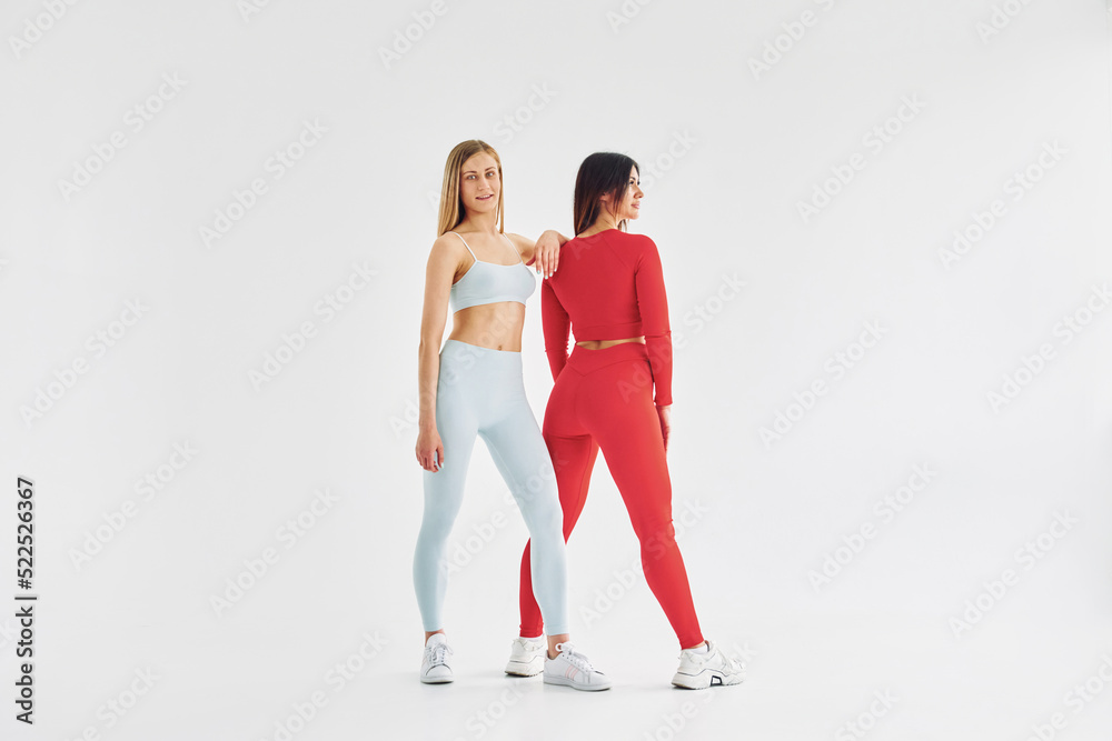 Red and white colored wear. Beautiful women in sportive clothes is indoors in the studio
