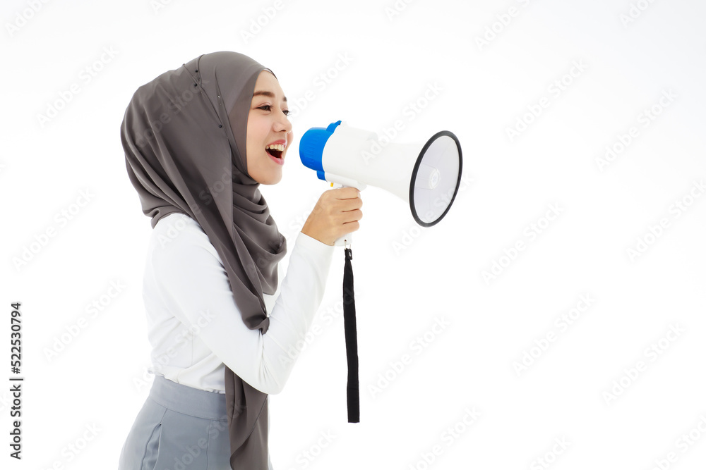 Young cute Muslim Arab woman wearing hijab speaking or shouting loud holding megaphone isolated on white background. Concept for advertising and marketing banner or billboard. Young cute Muslim Arab woman wearing hijab speaking or shouting loud holding megaphone isolated on white background. Concept for advertising and marketing banner or billboard.