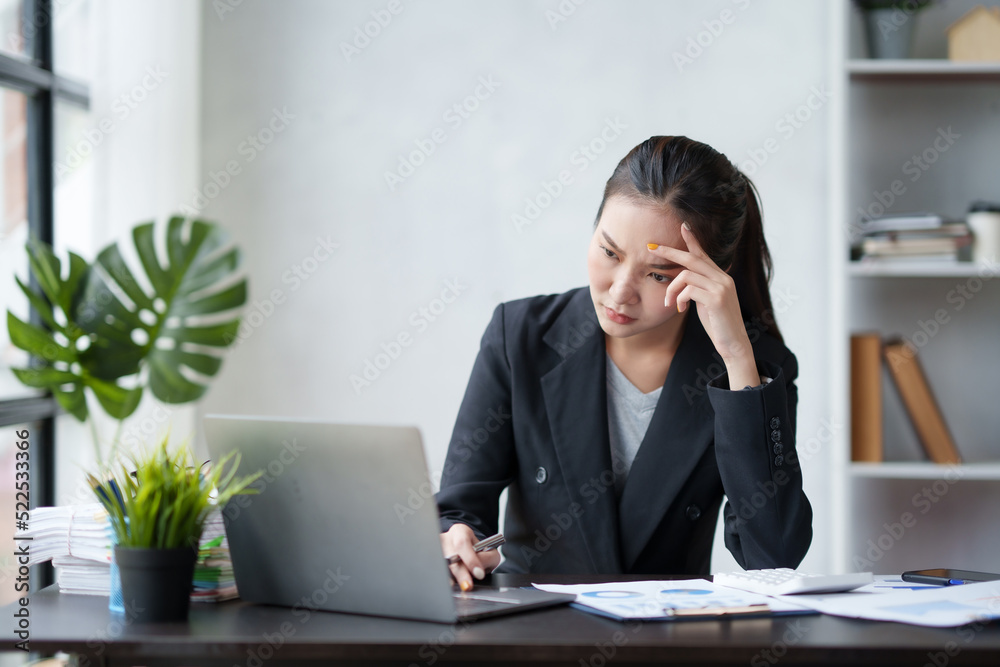 Beautiful Asian businesswoman is tired from working in the office. because of using too much eyes while working on laptop computer in office. Beautiful Asian businesswoman is tired from working in the office. because of using too much eyes while working on laptop computer in office.