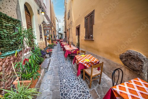 Tables and chairs in a picturesque alley in Castelsardo photo