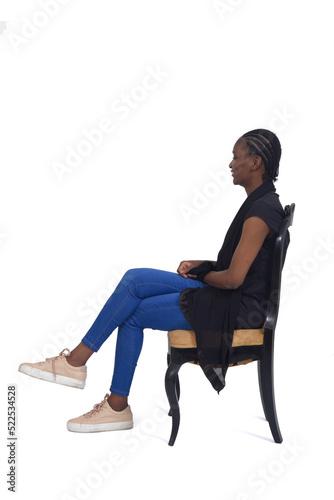 side view of a full portrait  of a woman sitting on chair cross-legged over white background