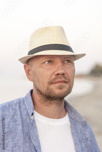 Man wear summer hat, relaxing on vacation. Close up portrait of thinking young man. Meditation, mental health, zen concept. Summer holiday.  © KatrinA