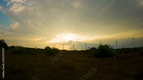 Time lapse of wind turbines spinning in the setting sun  through moving clouds near  Black Sea, Cape Kaliakra, Bulgaria
