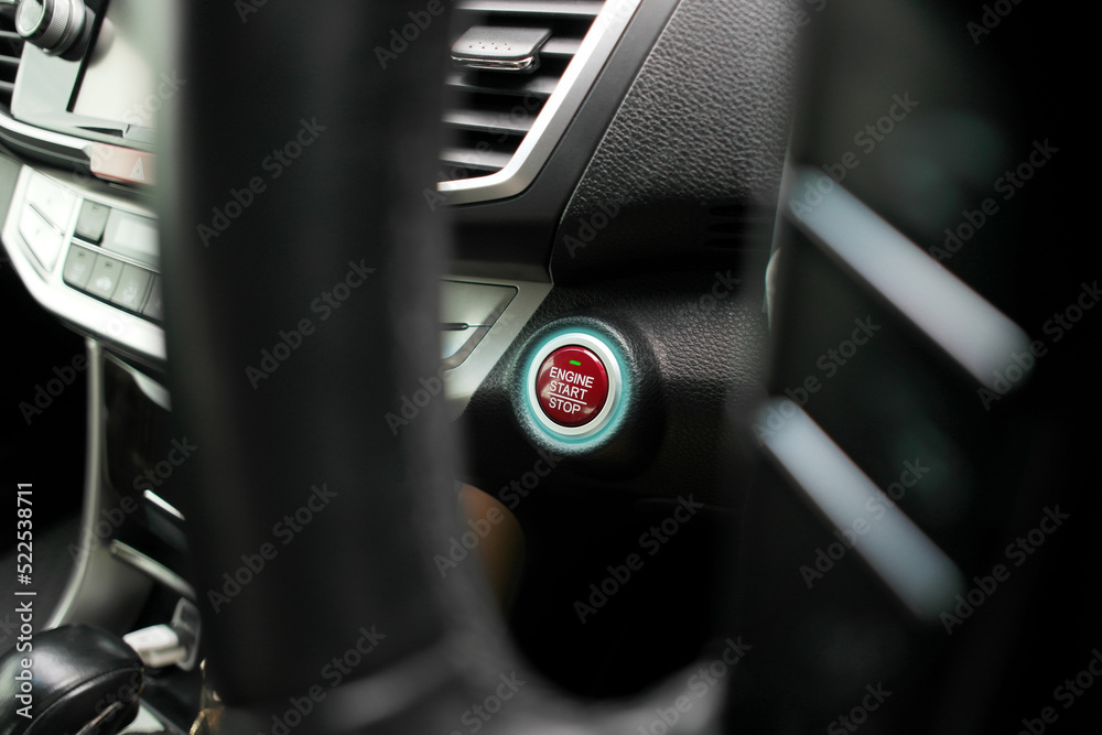 Red engine start stop button with an LED blue light on panel in a automobile Red engine start stop button with an LED blue light on panel in a automobile