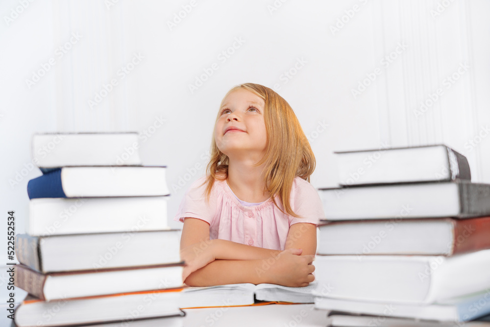Portrait of a pensive little girl with a lot of big books. Back to school. Portrait of a pensive little girl with a lot of big books. Back to school.