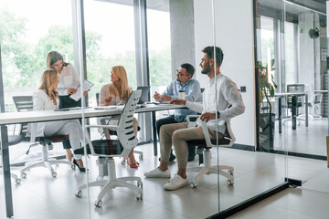 Talking and working on the project together. Group of professional business people is in the office
