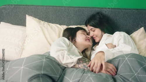 Concept of LGBT equality freedom friendship in the bedroom lesbian couple very in love kissing each other and touching with love