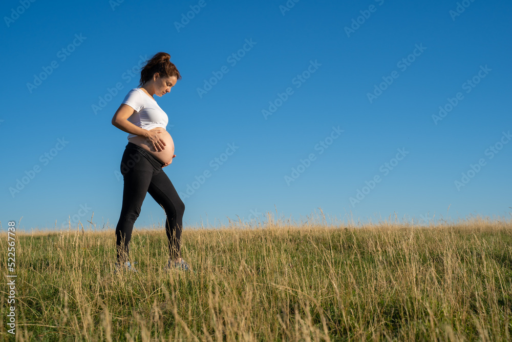 Pregnant woman walking in nature Pregnant woman walking in nature