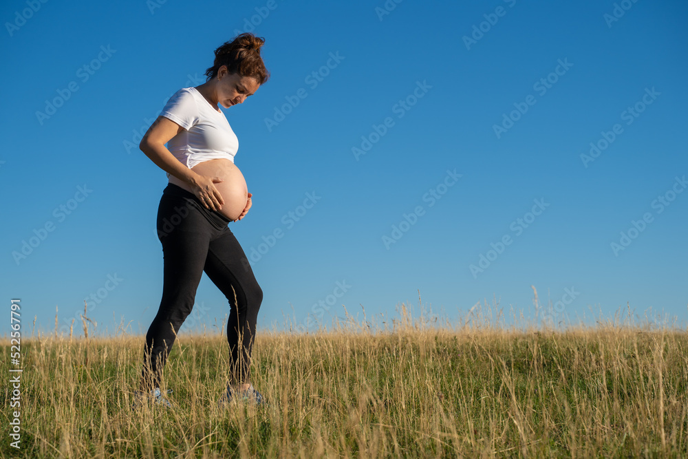 Pregnant woman walking in nature