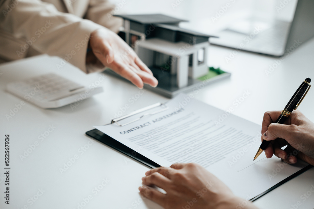Close up of business's hands selling and signing agreement paperwork for loan financial to buying the house properties. Close up of business's hands selling and signing agreement paperwork for loan financial to buying the house properties.