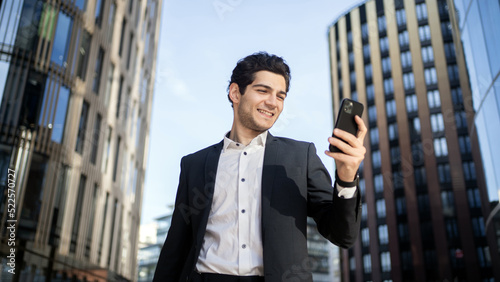 A businessman man uses the phone to work in the office in a business suit