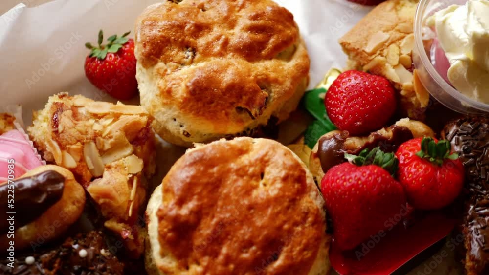 Cream tea with selection of cakes scones and sweets with strawberries Cream tea with selection of cakes scones and sweets with strawberries
