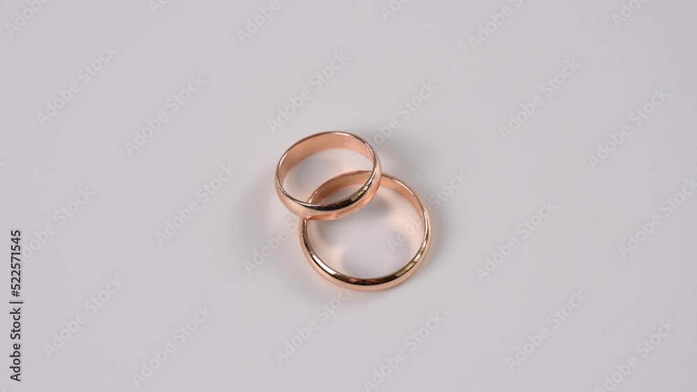 Two wedding rings spin on a white background. Two wedding rings spin on a white background.