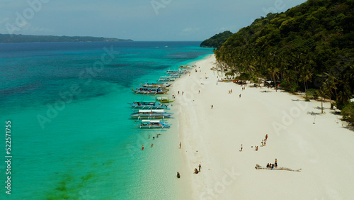 Sandy tropical beach with tourists and blue clear sea. Summer and travel vacation concept. Boracay, Philippines. Seascape with beach on tropical island. Puka shell beach photo