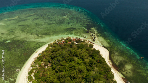 Tropical island in the blue sea with coral reef, top view. Small island with sandy beach. Summer and travel vacation concept, Mantigue island, Philippines, Mindanao