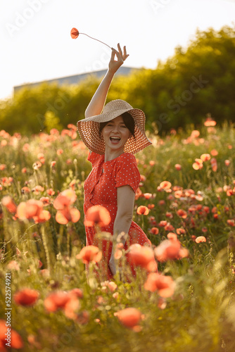 beautiful girl in a red dress on the background of a field of red poppies