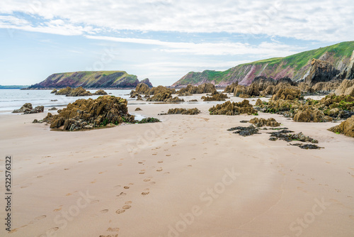 Фотография Marloes Sands Beach with rock formations at low tide, Wales