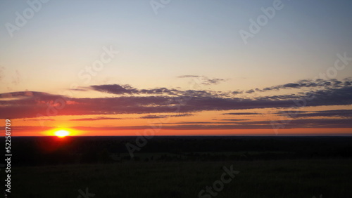 Rural landscape. A beautiful sunset on a hill and a forest stretching to the horizon. Leningrad region, Russia. photo