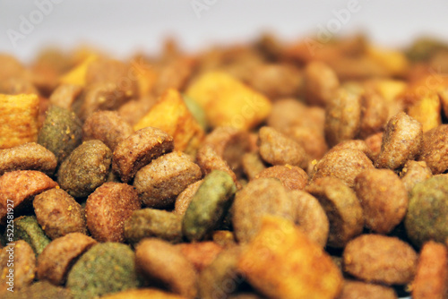 Dry food for cats, dogs lies in a pile on a light background. Close-up. Blurred background and background