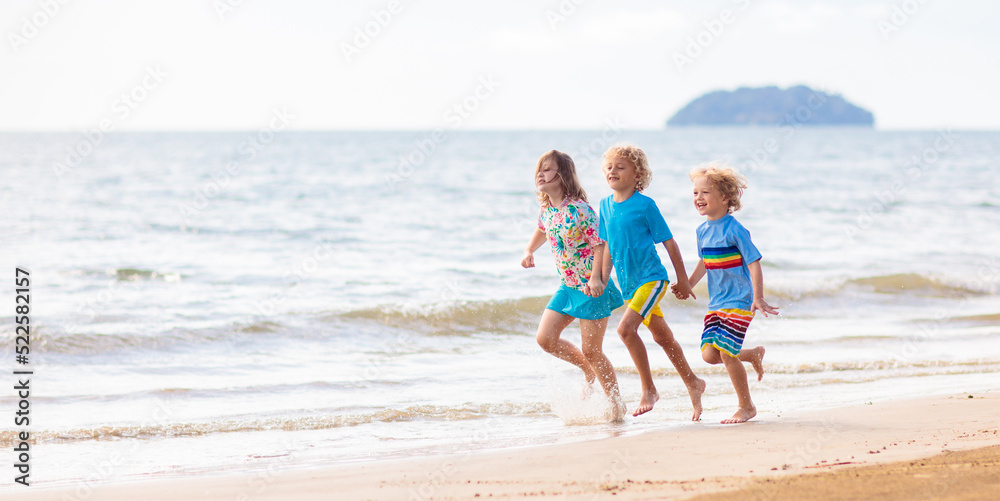 Kids playing on beach. Children play at sea.