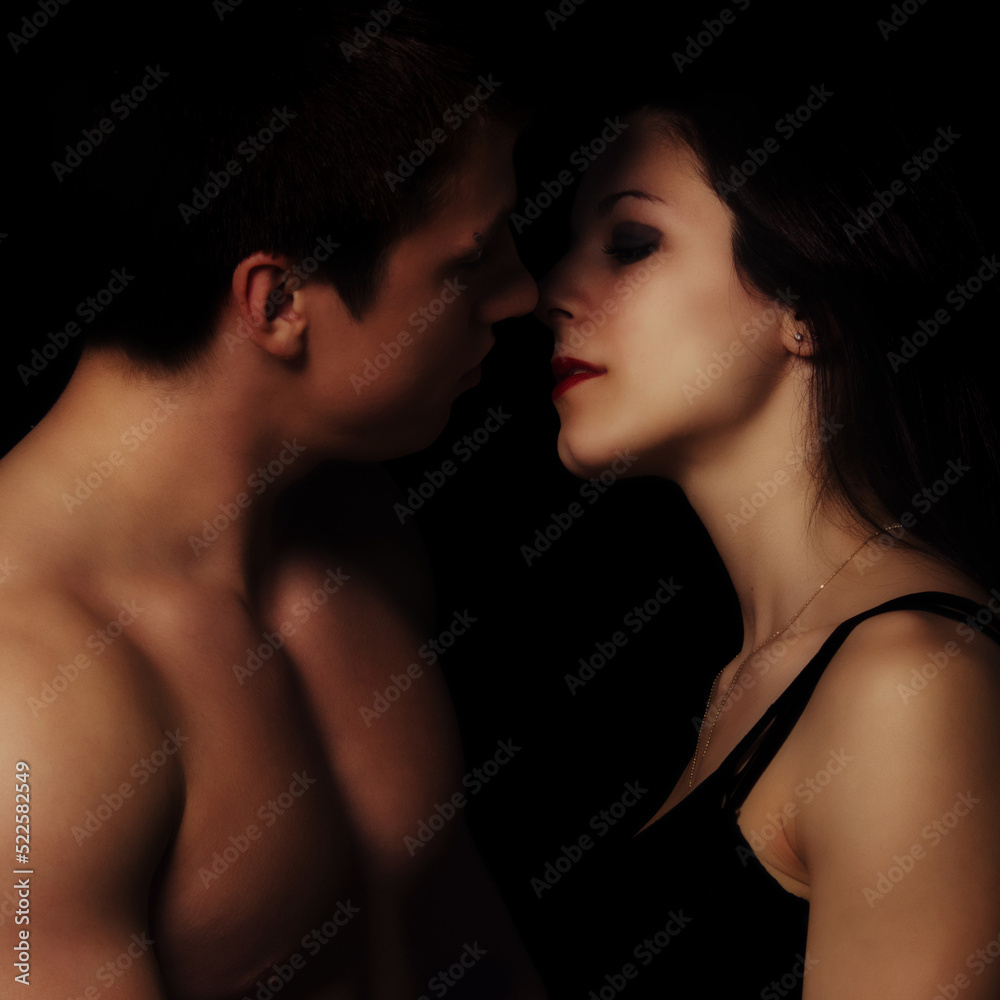 Young couple hugging and kissing as foreplay before having sex isolated on black background Young couple hugging and kissing as foreplay before having sex isolated on black background