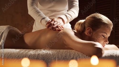 Young, healthy and beautiful woman gets massage therapy in the spa salon. Healthy lifestyle and body care concept.