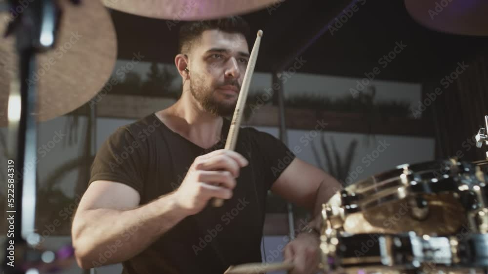 A handsome guy plays drums in a recording studio. Indie artist Create music. Rock style in the school of creativity. Learns to knock on a drum kit, beats the rhythm. Rocker plays solo, Slow motion A handsome guy plays drums in a recording studio. Indie artist Create music. Rock style in the school of creativity. Learns to knock on a drum kit, beats the rhythm. Rocker plays solo, Slow motion