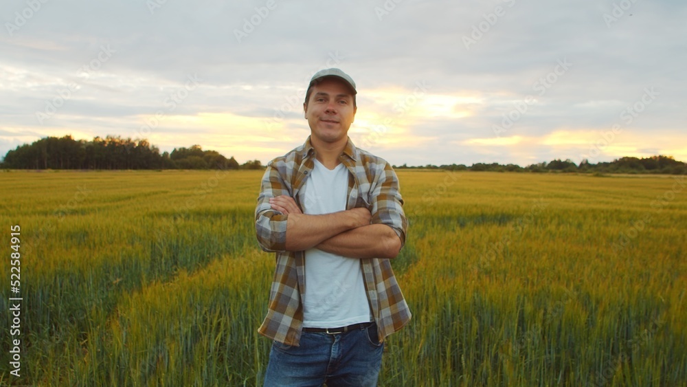 Farmer in front of a sunset agricultural landscape. Man in a countryside field. Country life, food production, farming and country lifestyle. Farmer in front of a sunset agricultural landscape. Man in a countryside field. Country life, food production, farming and country lifestyle.