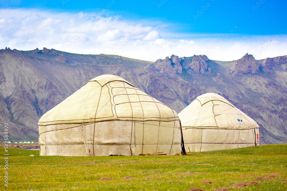 Yurt. National old house of the peoples of Kyrgyzstan and Asian countries. national housing. Yurts on the background of green meadows and highlands. Yurt camp for tourists in the mountains.
