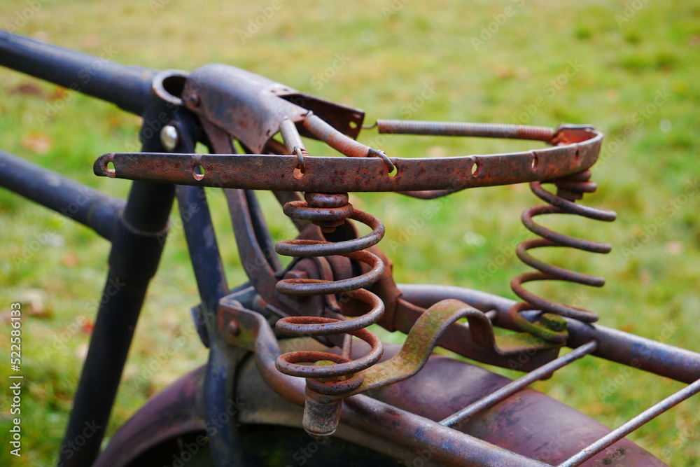 closeup of an old rusty broken saddle of an old cargo bike