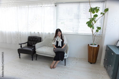 A Japanese woman checking smartphone by remote work in the home office