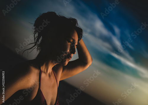 the last sunrays. 45-50 y.o. brunette woman on sunset beach