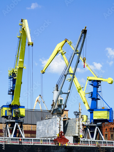 Wallpaper Mural Yellow and blue painted cranes load coal into a bulk carrier in the port Torontodigital.ca