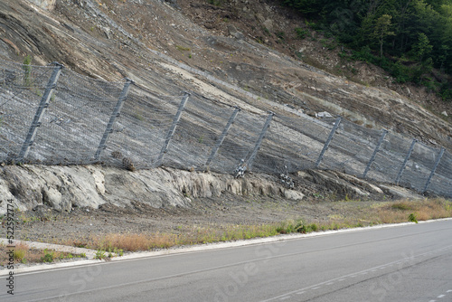Active robust rockfall barrier system with wire mesh along the road, brake for rocks fall. Slope strengthening after landslide in Tskneti Georgia.  photo