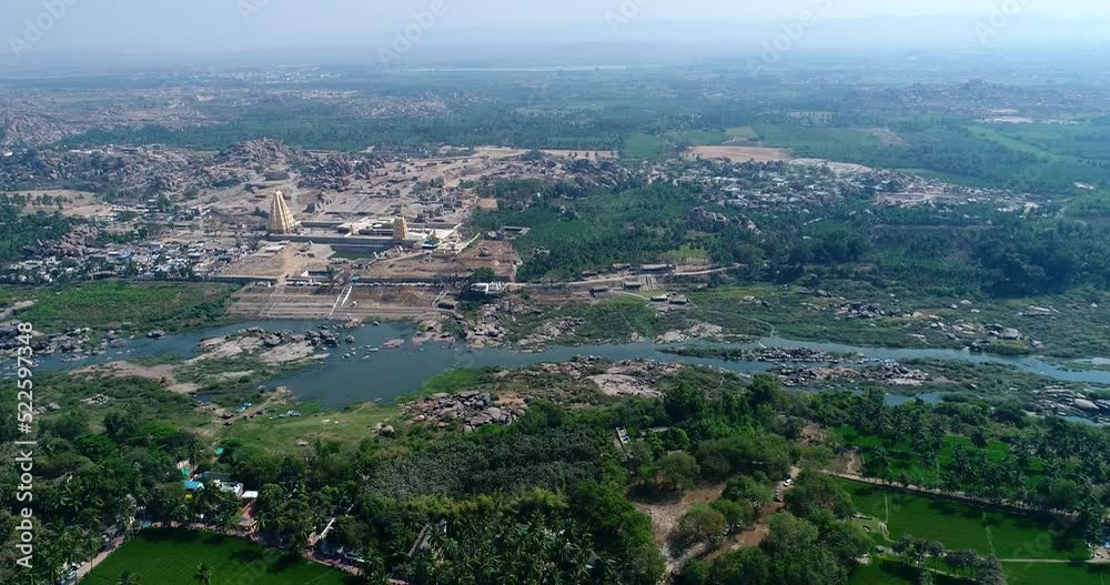 Aerial shot of Hampi temple complex with rice fields, river and village Aerial shot of Hampi temple complex with rice fields, river and village