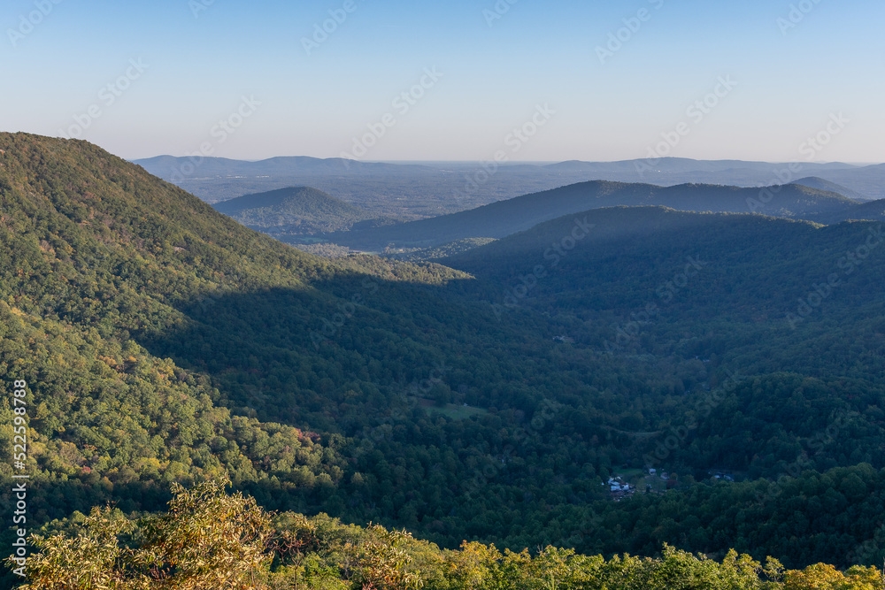 A town sits in a shaded valley in the Blue Ridge Mountains as viewed from Shenandoah National Park