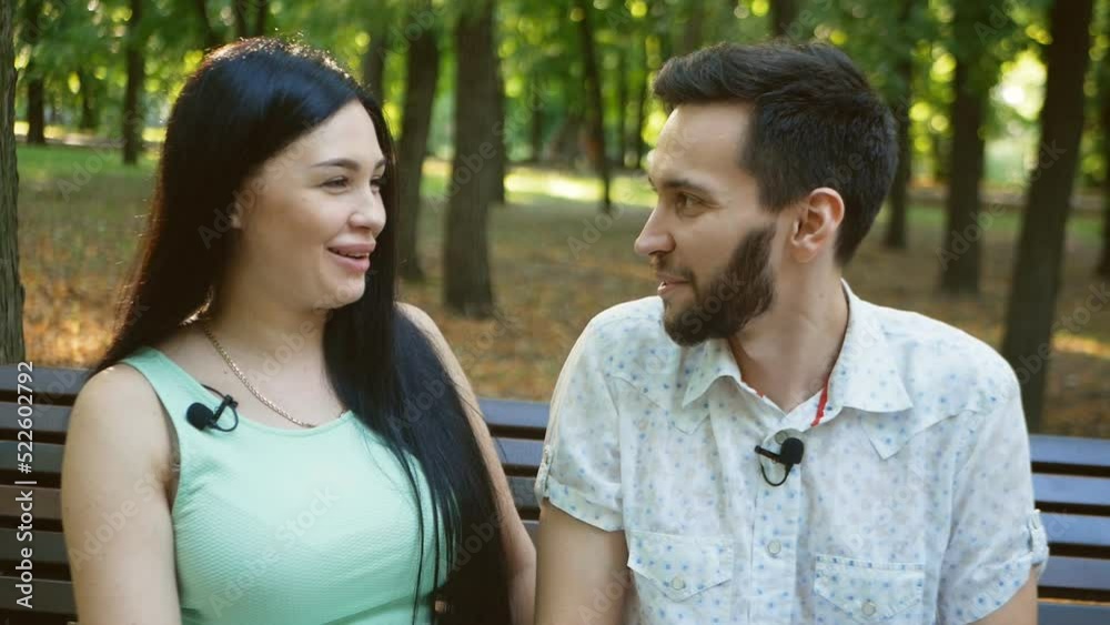 Interview with a young couple in the park for a blog. conversation funny moments in life Interview with a young couple in the park for a blog. conversation funny moments in life