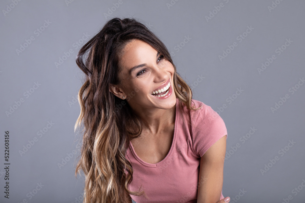 Beautiful young woman smiling on a gray background. Beautiful young woman smiling on a gray background.