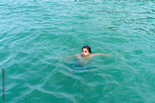 garoto nadando sozinho em águas translúcidas do Mar Mediterrâneo  © Luciano Ribeiro