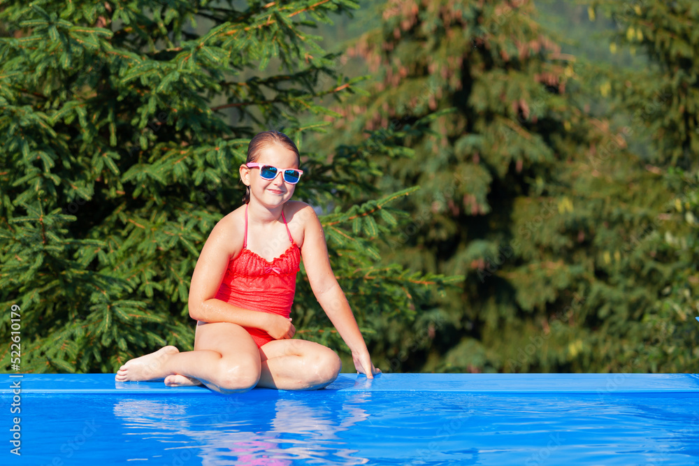 cute girl playing in outdoor swimming pool. Summertime Water Fun.