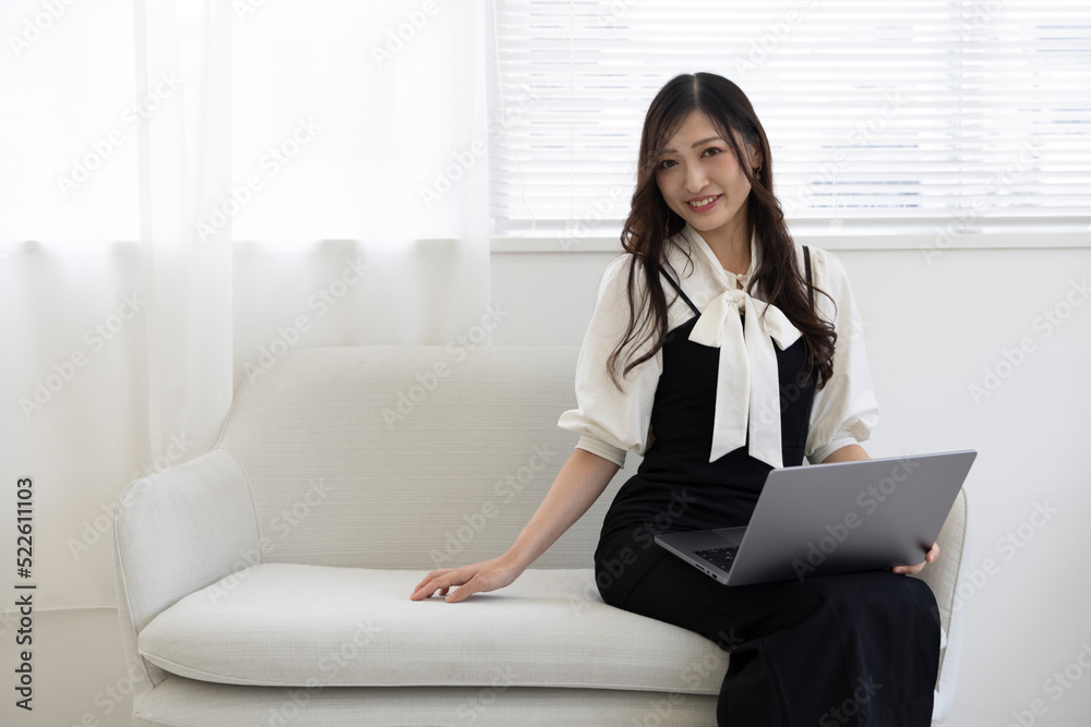 A Japanese woman checking smartphone by remote work in the home office A Japanese woman checking smartphone by remote work in the home office