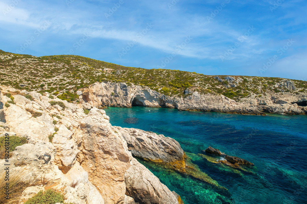 Rocky Porto Limnionas beach on Zakynthos island, caves in the bay, beautiful crystal clear color Ionian sea