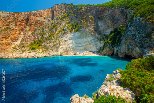 Beautiful bay on the island of Zakynthos, turquoise clear Ionian sea, cozy little beach surrounded by high rocks, summer day on the island of Zante